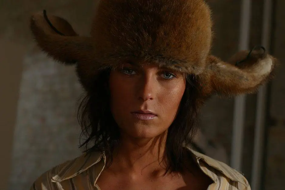 Portrait of a woman wearing a fur hat, showcasing bold fashion and captivating gaze.