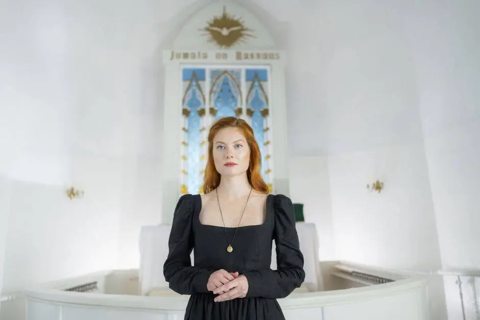 Redhead woman standing in a church interior, symbolizing faith and elegance in a peaceful, sacred atmosphere.